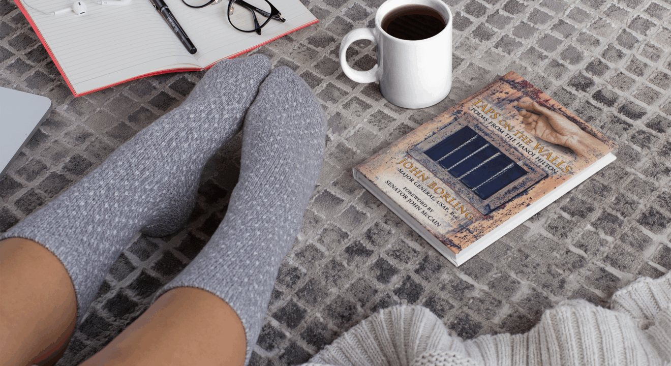 Stack of Vietnam War books with a flickering candle and American flag, representing recommended reading related to Taps on the Walls by Master Wings Publishing